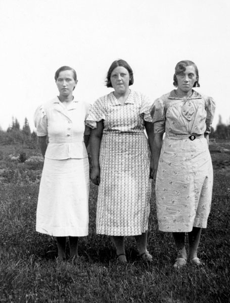 Tre kvinnor poserar framför kameran.