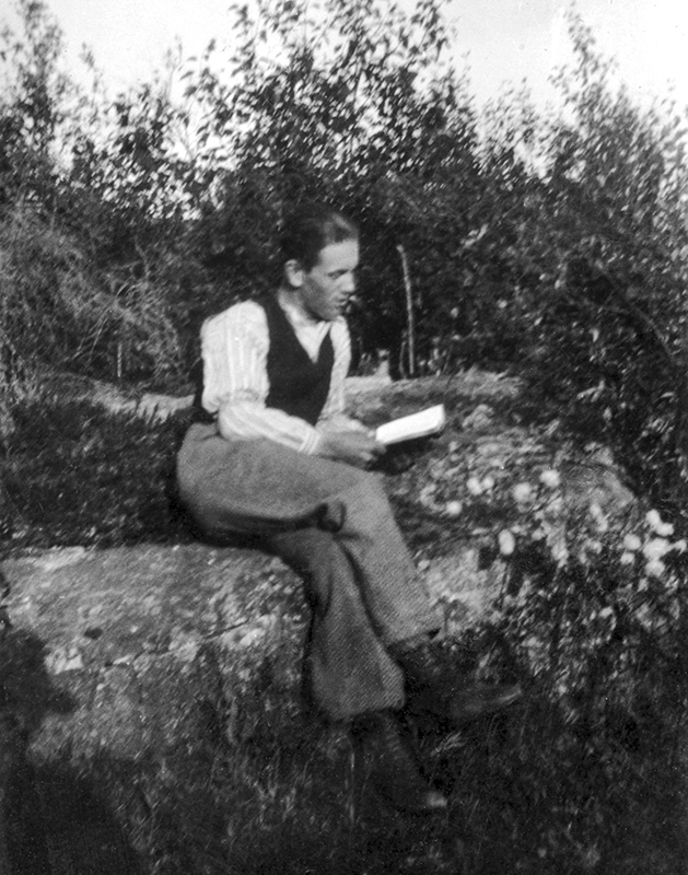 Holmfrid Hellgren sitter ute och läser en bok.