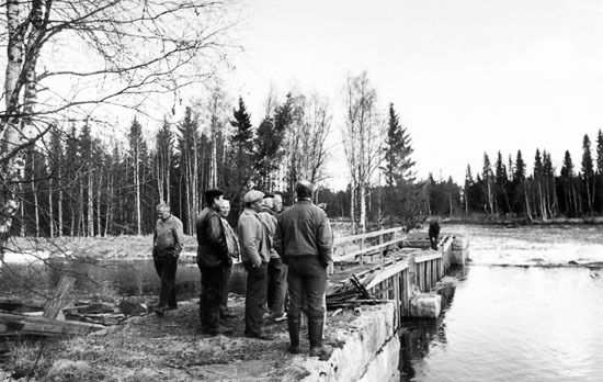 En grupp män inspekterar kanalintaget 