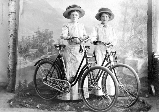 Kvinnor som poserar med cyklar inför fotografen.