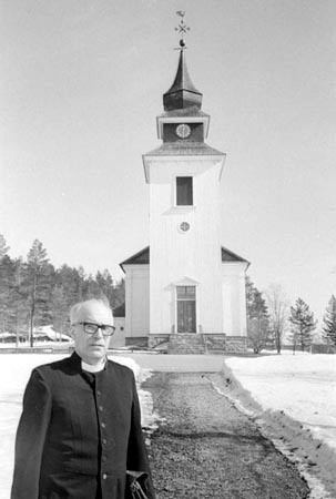 Kyrkoherde Sven Billfors framför Vilhelmina kyrka.