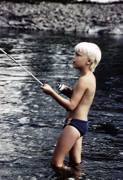 Liten pojke som fiskar med haspelspö 