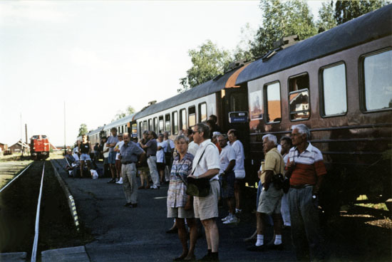 Resenärer utanför sitt tåg vid inlandsbanan.