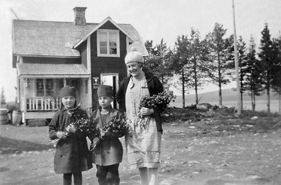 Lärarinnan Greta Sundström med två okända barn.
