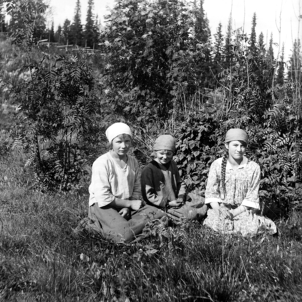 Tre okända flickor i gräset.