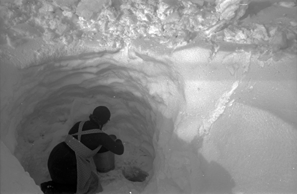 Elise hämtar vatten i tre meter djup snö.