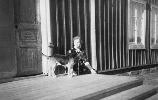 Agnes Risberg med en hund på trappan.