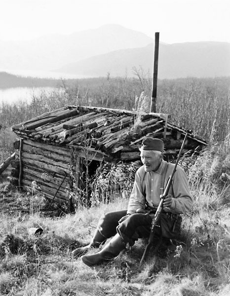 Erik Viktorsson sitter intill kojan vid Gitssjön.