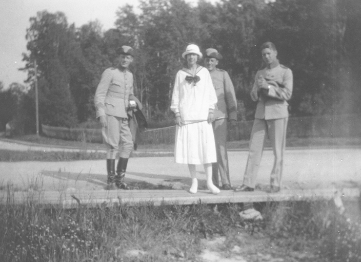Tre inkallad soldater och en kvinna står på vägen.