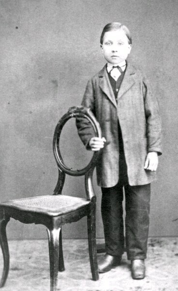 En okänd poke står vid en stol.
