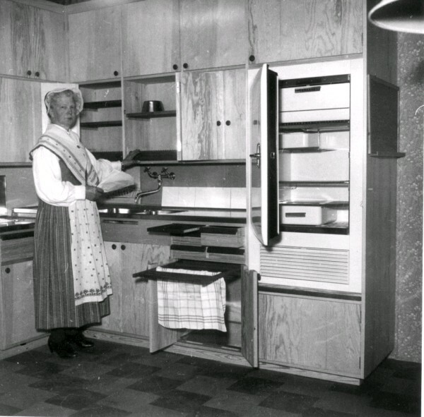 Kvinna iklädd sockendräkt demonstrerar ett kök.