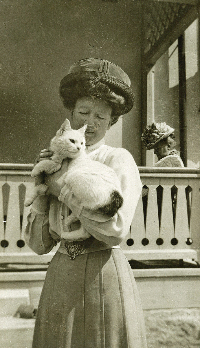 Ebba Frendin (1875-1952) hållandes i en vit kat...