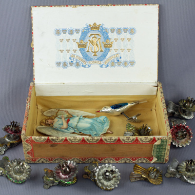SLM 26857 - Cigarrlåda med julpynt, ljushållare av bleckplåt, glasfågel, pappängel
