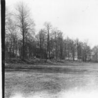 SLM A4-113 - Boningshuset skymt av trädparti, Väderbrunn i Bergshammars socken år 1953