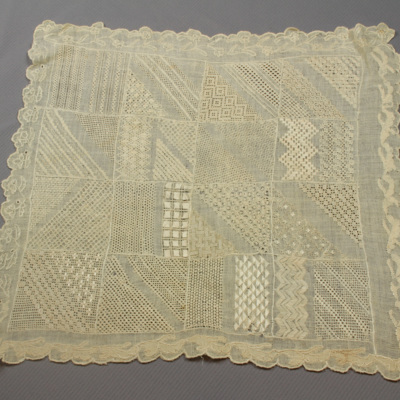SLM 8154 - Sömnadsprov, mönsterduk av bomull med broderier i silke, troligen 1800-tal