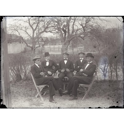 SLM X10-596 - Fem herrar sittande vid trädgårdsmöbel