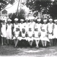 SLM X1963-78 - Klassfoto med elever i tjänsteuniform i en trädgård