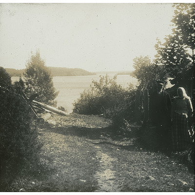 SLM DIA2022-0129 - Äldre par framför sjön Klämmingen, 1900-tal