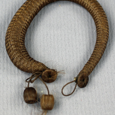 SLM 8325 2 - Armband, hårarbete, rundflätat med två håröverklädda träkulor