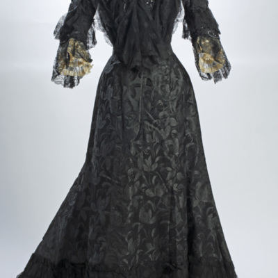 SLM 11862 - Klänning av svart mönstervävt siden och korsetterat liv, 1800-talets slut