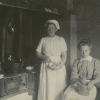 SLM P10-699 - Två flickor lagar mat vid vedspis, sannolikt är en av dem Linnea Haglund f. Andersson (1915-1988)
