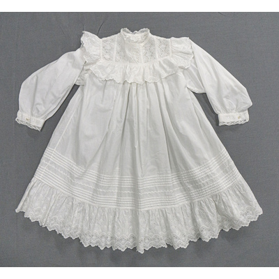 SLM 52595 - Kolt/klänning av vit bomull, prydd med volanger och spetsar