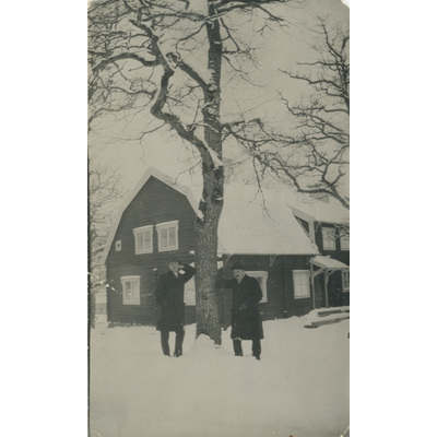 SLM P2022-1368 - Två män står ute i snön och röker