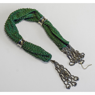 SLM 37884 - Virkad långbörs av grönt silke med ringar och hängen av vitmetall, 1800-talets andra hälft