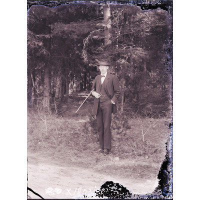 SLM X1803-78 - En man med gevär står framför en skog