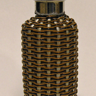 SLM 11937 - Parfymflaska klädd med silverfärgade vidjor och flätade band, hals och skruvkork av vitmetall