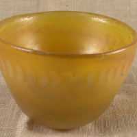 SLM 28183 - Skål av guldgult glas, iriserande sida och olivslipning, möjligen från Kosta