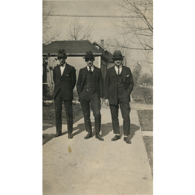 SLM P2022-1255 - Tre kostymklädda män på en gångväg