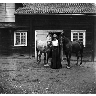 SLM Ö636 - Kvinna med två hästar på ladugårdsbacken vid Ökna säteri i Floda socken