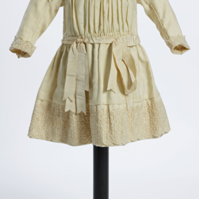 SLM 11700 - Flickklänning av gulvitt ylletyg med brodyrdekorationer, 1800-talets slut