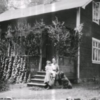 SLM M036565 - Kvinna med barn och hund framför ett hus