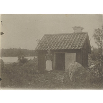 SLM R1025-92-5 - Kvinna vid hus vid Måstena