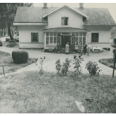 SLM P09-1609 - Fem personer framför ett hus