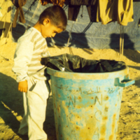 SLM P07-2331 - En pojke letar efter något att leka med i en soptunna i ”Ingenmansland”.