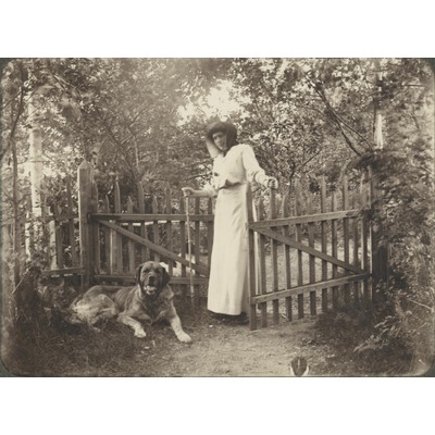 SLM P09-1508 - Porträtt av kvinna och hund vid en grind