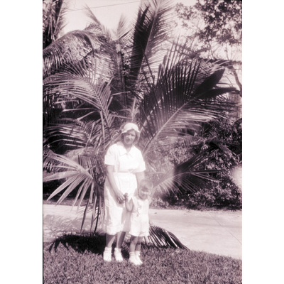 SLM X2022-0047 - Gertrud Höglund och ett barn framför en palm
