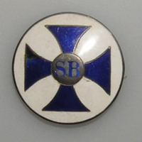 SLM 33562 1-2 - Brosch, barnmorskenål, rund med blått kors mot vit bakgrund