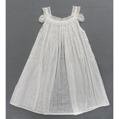 SLM 52515, 52606 - Två barnförkläden av tunn vit bomull prytt med spetsar, tidigt 1900-tal