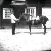 SLM Ö607 - Man med sadlad häst på ladugårdsplanen vid Ökna säteri i Floda socken