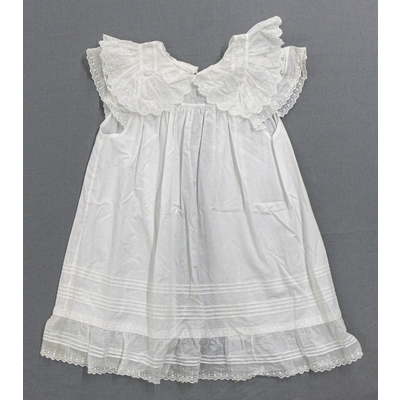 SLM 52564 - Barnförkläde av vit linnebatist prytt med spetsar, tidigt 1900-tal