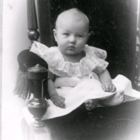 SLM M033592 - Finklädd litet barn sittande i en stol