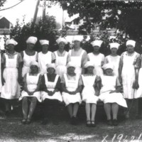 SLM X1962-78 - Klassfoto med elever i tjänsteuniform i en trädgård