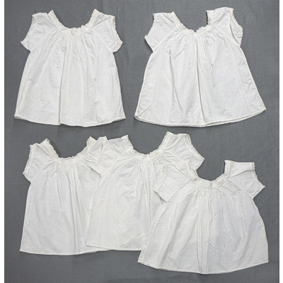 SLM 52627, 52631, 52632, 52633, 52665 - Fem barnsärkar av vit bomull, dekorerade med band och spetsar
