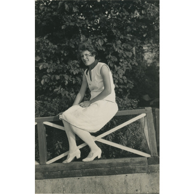 SLM P2022-1348 - Kvinna sitter på ett räcke