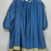 SLM 5954 - Barnklänning av blå yllecrepe kantad med smårutigt ylletyg, 1920- 30-tal