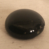 SLM 3121 - Rundad glättsten av svart glas, från Trosa